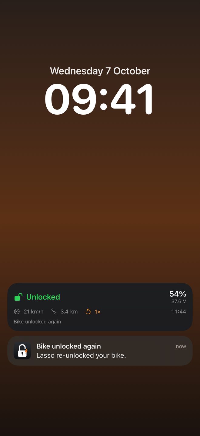 iPhone Lock Screen showing the Lasso Live Activity and a 'Bike unlocked again' notification